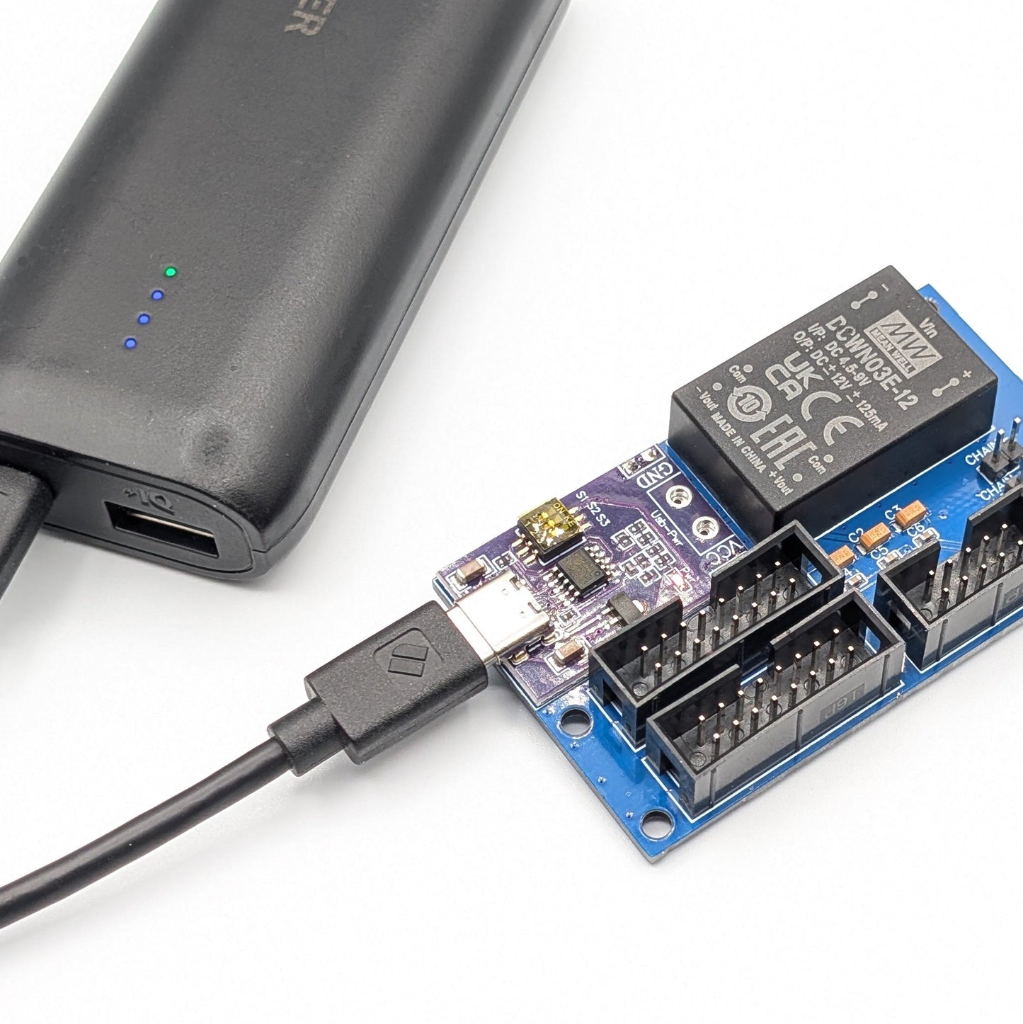 Power eurorack module with connectors and a power bank on a white background